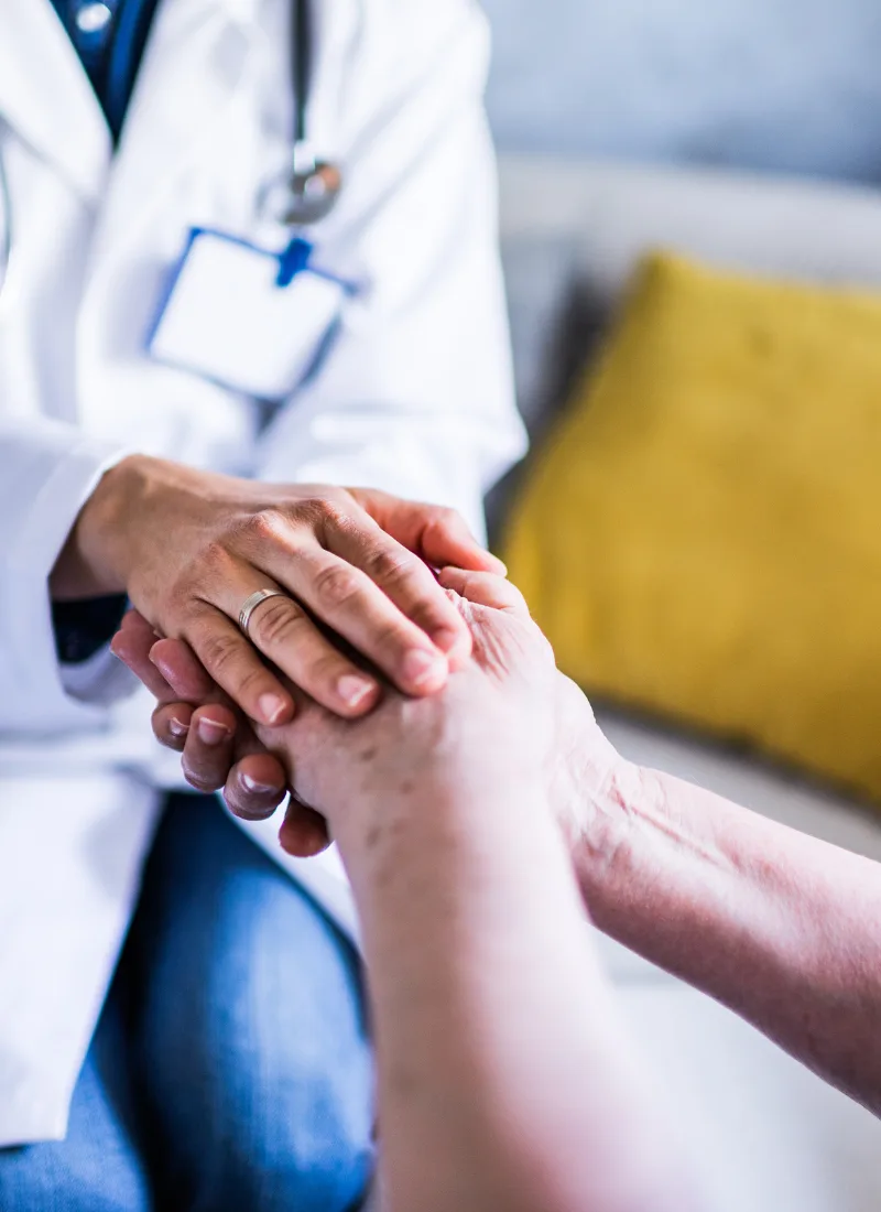 compassionate primary care visit holding senior patient hands